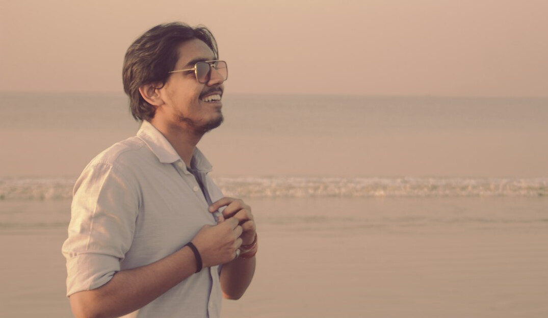 Latin American man in his fifties with short grey hair and glasses wearing a casual shirt smiling at the camera