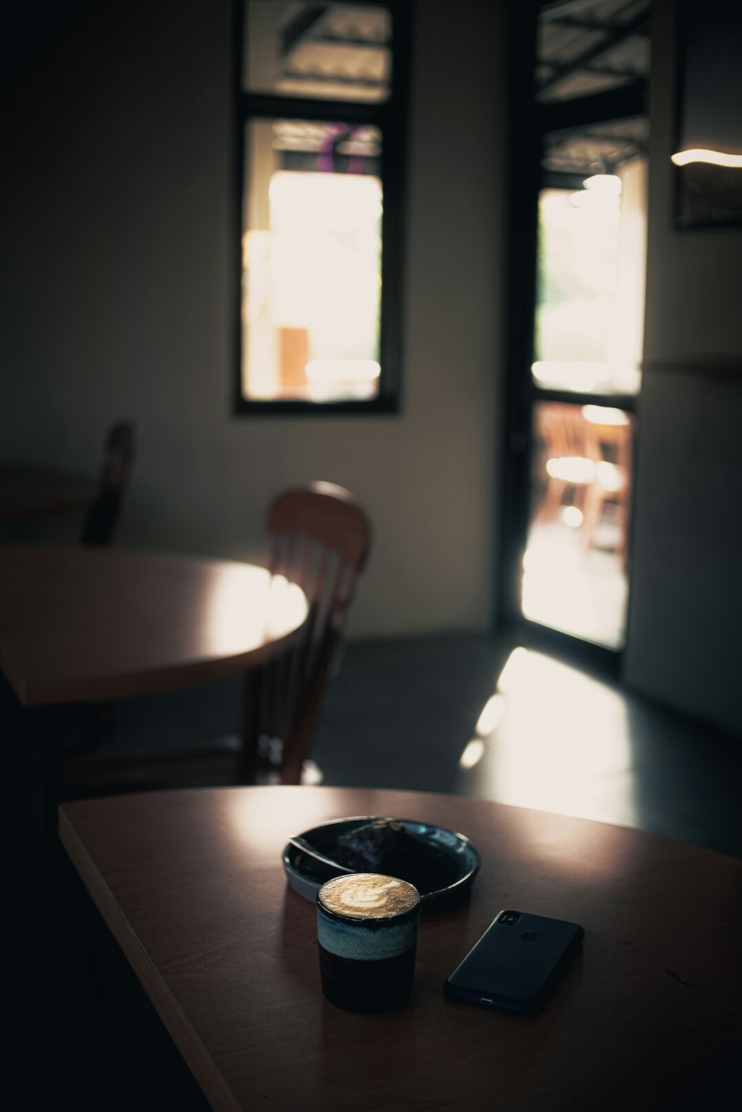 Wooden desk with notebook, calculator and coffee cup seen from above in morning light