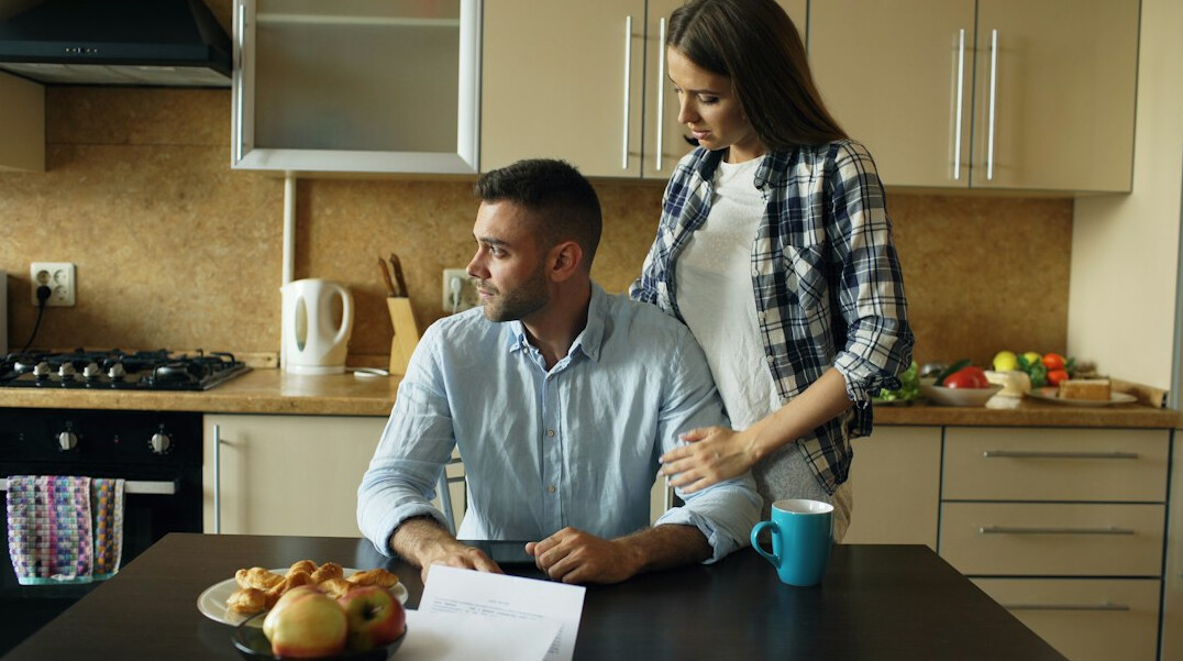 person checking bills at kitchen table